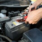 Car battery with jumper cables, indicating a potential battery issue causing starting problems