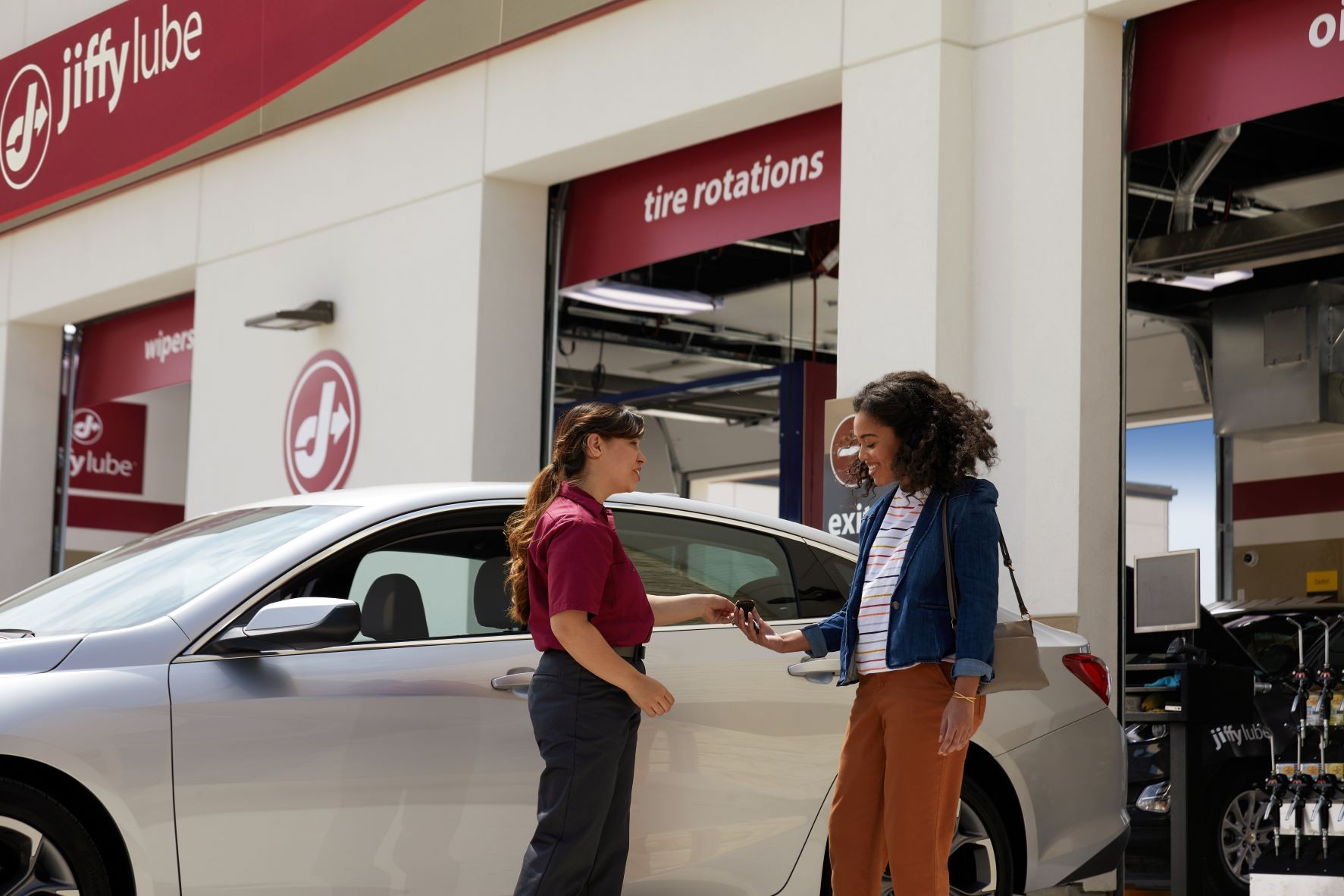 Woman in discussion with a Jiffy Lube technician about her car's diagnostic test results