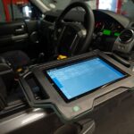 Technician using diagnostic equipment on a car