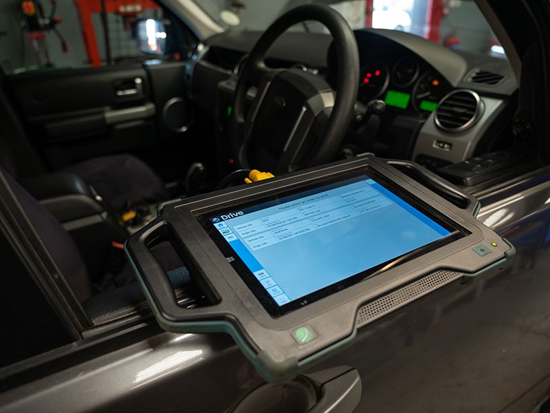 Technician using diagnostic equipment on a car