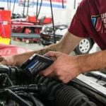 A mechanic using a diagnostic tablet to diagnose a car