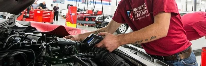 A mechanic using a diagnostic tablet to diagnose a car