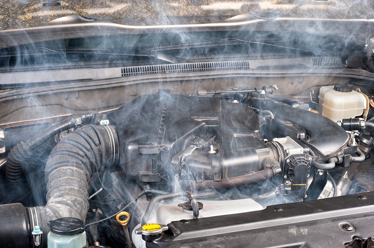 Engine Overheating Symptom of Bad Thermostat: Steam rising from a car engine, indicating potential thermostat failure.